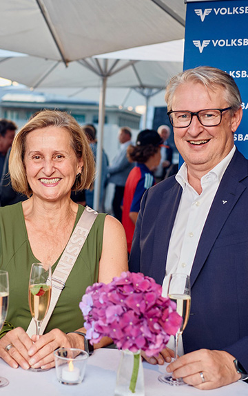 Auf dem Bild ist eine Frau und ein Mann an einem Stehtisch zu sehen. 