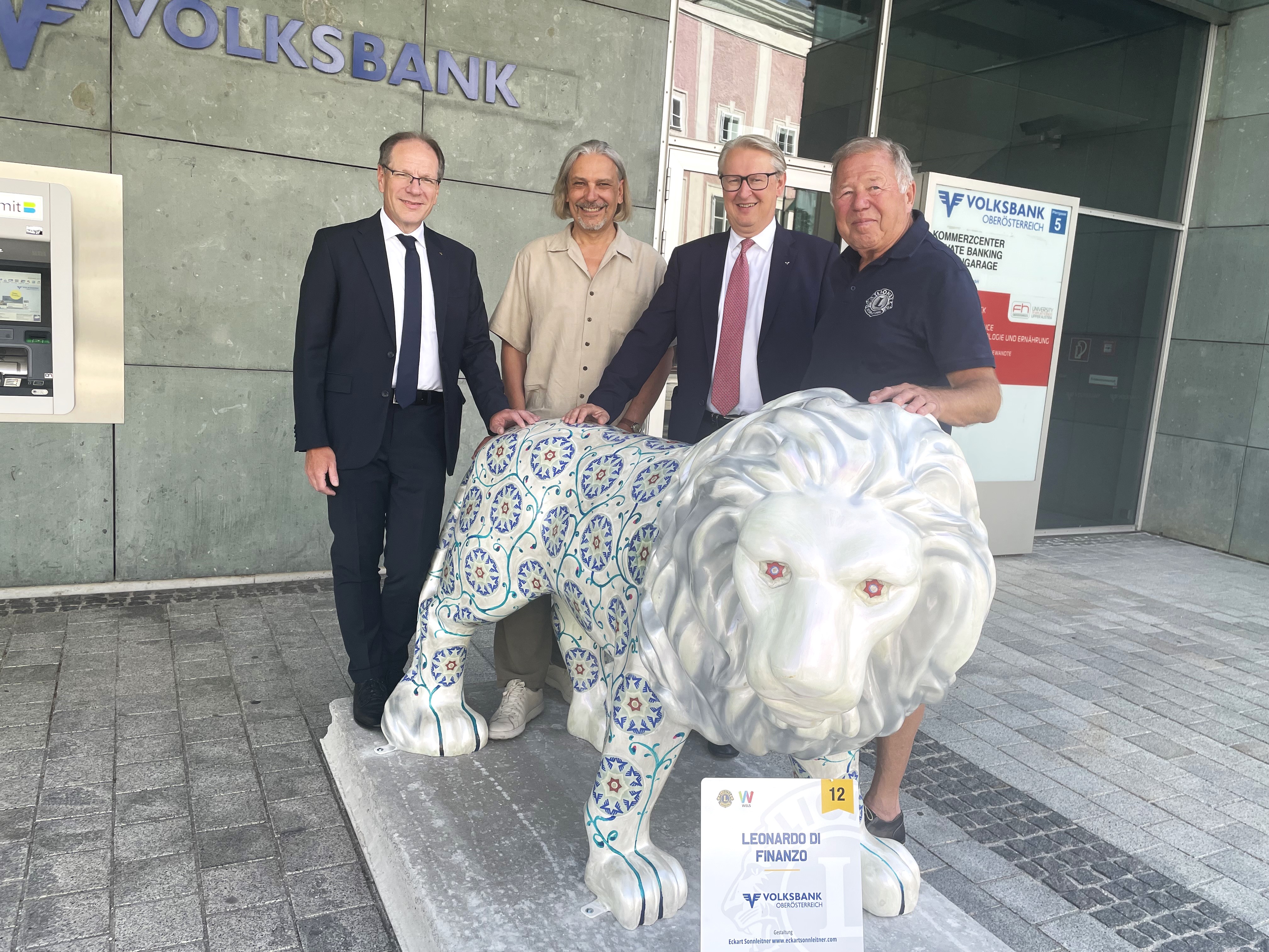 Auf dem Bild sieht man unseren Volksbank Oberösterreich Löwen mit 4 Männer. Fotohinweis im Text. 
