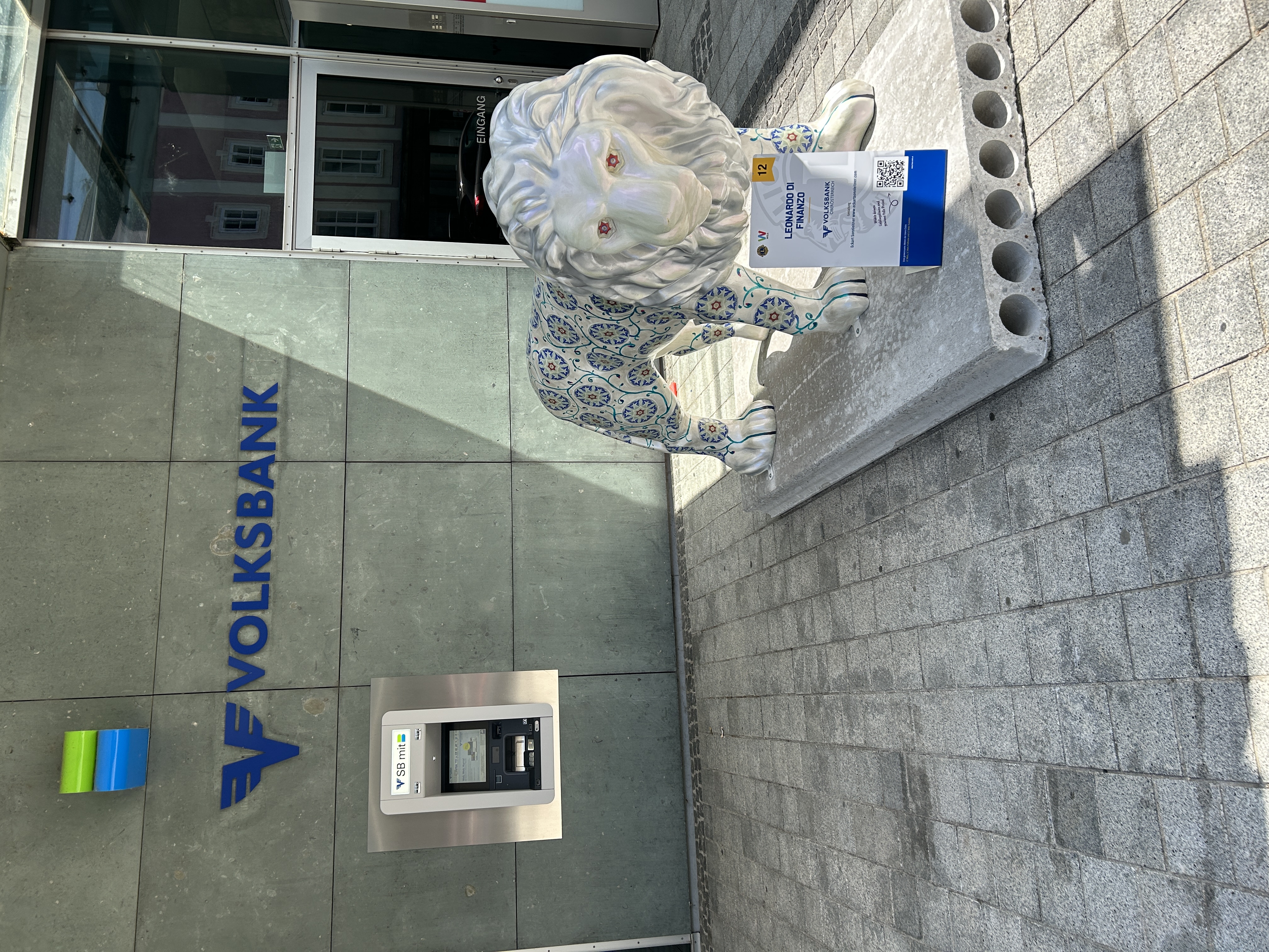 Auf dem Foto sieht man unseren Volksbank Löwen vor unserer Filiale in Wels.