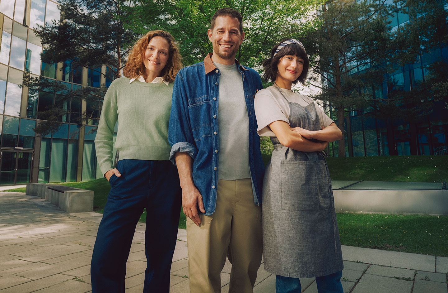 Ein Unternehmer und zwei Unternehmerinnen stehen nebeneinander. Sie blicken selbstbewusst in die Kamera.